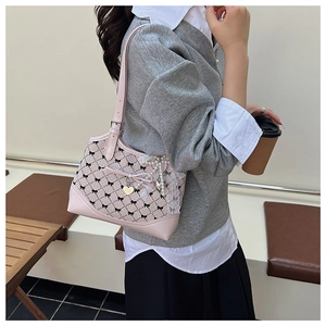 Close-up of pink plaid canvas bag with lace trim and heart pearl charm detail
