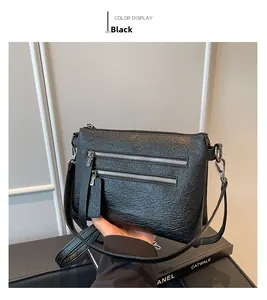 Detail of a black pleated leather shoulder bag with vintage metal zipper pockets