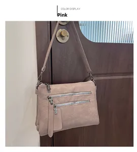 Close-up of pink pebbled faux leather shoulder bag with two metal zipper pockets