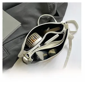 Top view of white leather crossbody bag interior showing multiple compartments and capacity
