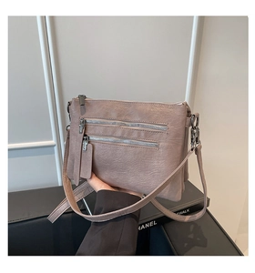 Close-up of vintage pink crossbody bag featuring multi-pocket design and soft leather texture