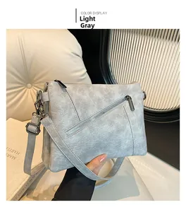 Detail of light grey crossbody bag featuring textured PU leather and zipper pocket