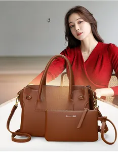 Dettaglio borsa tote in pelle marrone con grana litchi, fibbia dorata e pochette