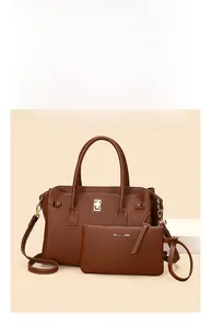 Dettaglio del set di borse marroni in pelle martellata con serratura dorata e pochette