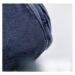 Macro shot of durable dark blue denim fabric with reinforced stitching and twill texture