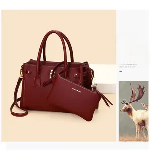 Dettaglio della borsa tote bordeaux in pelle granata con dettagli dorati e pochette interna
