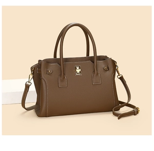 Dettaglio della borsa tote in pelle martellata con cuciture bianche e chiusura oro
