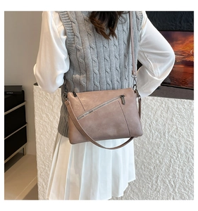 Detail view of mauve crossbody bag with functional diagonal zipper and adjustable strap