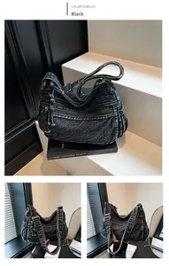 Detail of washed black denim shoulder bag with fringe tassel and functional zippers