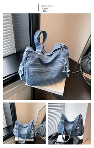 Close-up of light blue denim shoulder bag with floral zipper pulls and multiple pockets