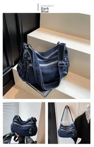 Close-up of deep blue denim crossbody bag with multiple zip pockets and adjustable strap