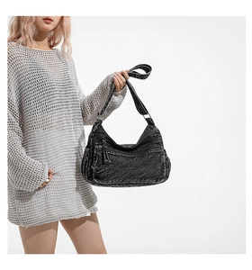 Detail of black washed denim tote bag showing vintage texture and multiple zipper pockets