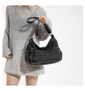 Detailed view of vintage black washed denim shoulder bag showing pockets and texture