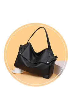 Close-up of black leather tote bag with lychee grain texture and metal rivet detail