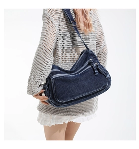 Detail of vintage denim crossbody bag showing multi-pocket design and adjustable strap