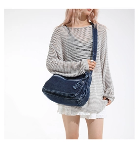 Detailed view of washed denim crossbody bag featuring multi-pocket design and adjustable strap