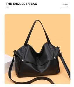 Detail view of large black pebble grain leather tote bag with silver studs and straps