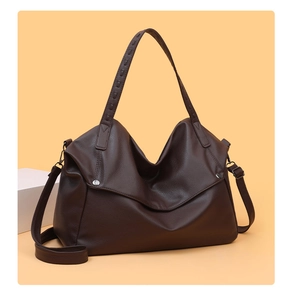 Detail of dark brown leather tote bag showing lychee grain texture and silver hardware