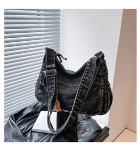 Close-up of vintage black washed denim hobo bag with adjustable strap and metal hardware
