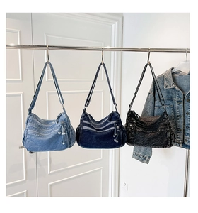 Three washed denim messenger bags in light blue, dark blue, and charcoal grey shades