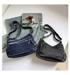 Detailed flat lay of denim shoulder bags in navy and grey with functional zipper pockets