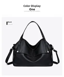 Detail of black pebbled leather tote bag with silver buckle and adjustable shoulder strap