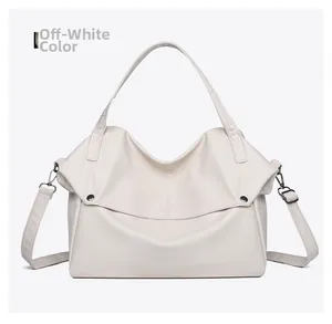 Detail of cream tote bag showing fine pebble leather texture and metal snap button closure