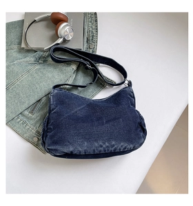 Detailed overhead view of the washed dark blue denim shoulder bag with soft fading