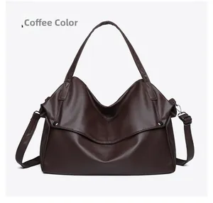 Detail of coffee brown tote bag showing textured leather surface and metal buckle