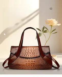 Detail of vintage brown crocodile embossed texture and bronze hardware on hand bag