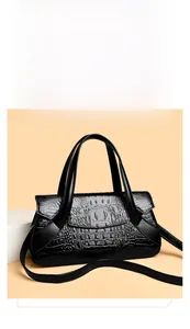 Detail of black crocodile texture handbag with dual handles and elegant flap closure