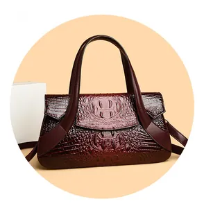 Close-up of crocodile pattern texture on a deep burgundy leather handbag for women
