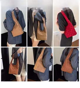 Modella con borsa hobo in pelle scamosciata vintage con borchie in caffè scuro, tan e rosso