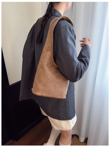 Detail view of a vintage frosted bucket bag with silver studs and quilted patterns
