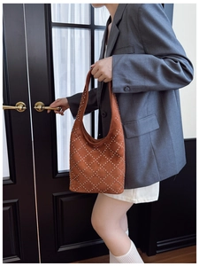 Detail of caramel hobo bag featuring silver punk rivets and vintage suede texture