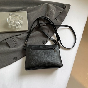 Fashionable black faux leather crossbody bag with multiple pockets and vintage textures