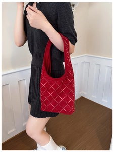 Dettaglio della borsa tote in pelle scamosciata rossa con borchie argentate a rombi