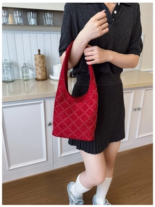 Close-up of red suede bucket bag with silver metal rivets in a rhombic pattern