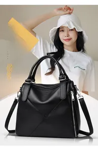Detail of black pebbled leather tote bag with dual handles and side metal zipper feature