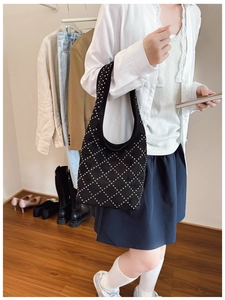 Detailed view of black frosted tote bag with silver rivets in a diamond pattern