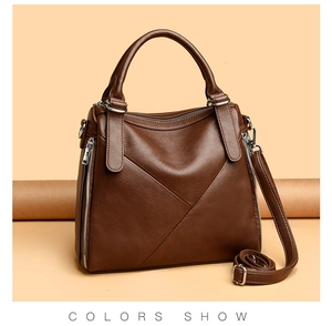 Detailed view of dark brown textured leather handbag with silver zippers and elegant stitching