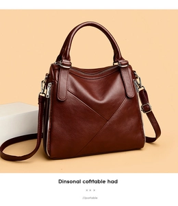 Close-up of wine red pebble leather handbag with cross-stitch design and silver metal zipper