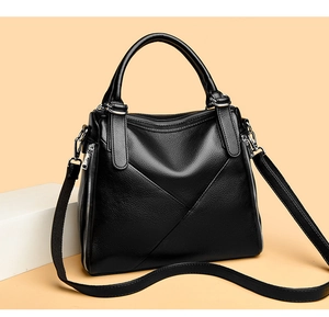 Detail of black pebbled leather bag featuring V-shaped stitching and silver metal zippers