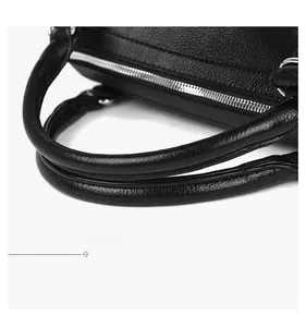 Close-up of pebble grain leather handle with silver metal zipper on black tote bag