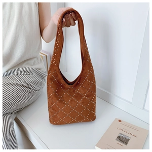 Dettaglio della borsa hobo in camoscio marrone con borchie argentate e tracolla larga