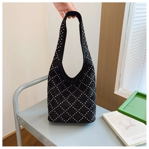 Dettaglio borsa hobo in pelle scamosciata nera con motivo trapuntato a pois bianchi