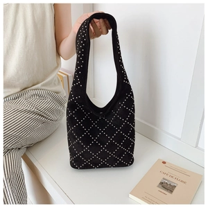 Detail of black suede hobo bag with silver metal rivets in diamond lattice pattern