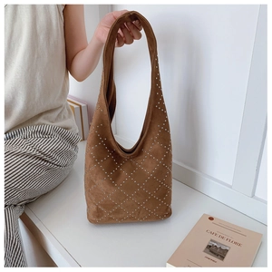 Dettaglio borsa hobo in pelle scamosciata marrone scuro con borchie a rombi
