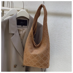 Detail of brown suede Hobo bag with silver studs in a diamond pattern on display