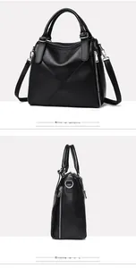 Detail of black pebbled leather tote bag with silver zippers and removable strap